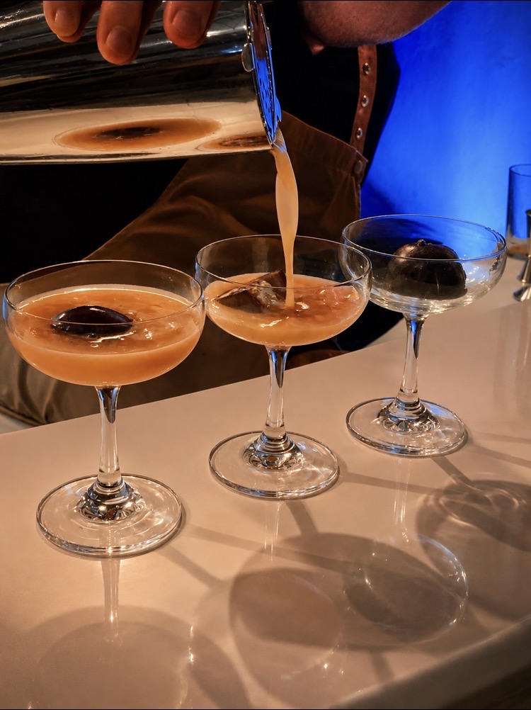 Three espresso martinis being poured at a mobile cocktail bar in Norfolk