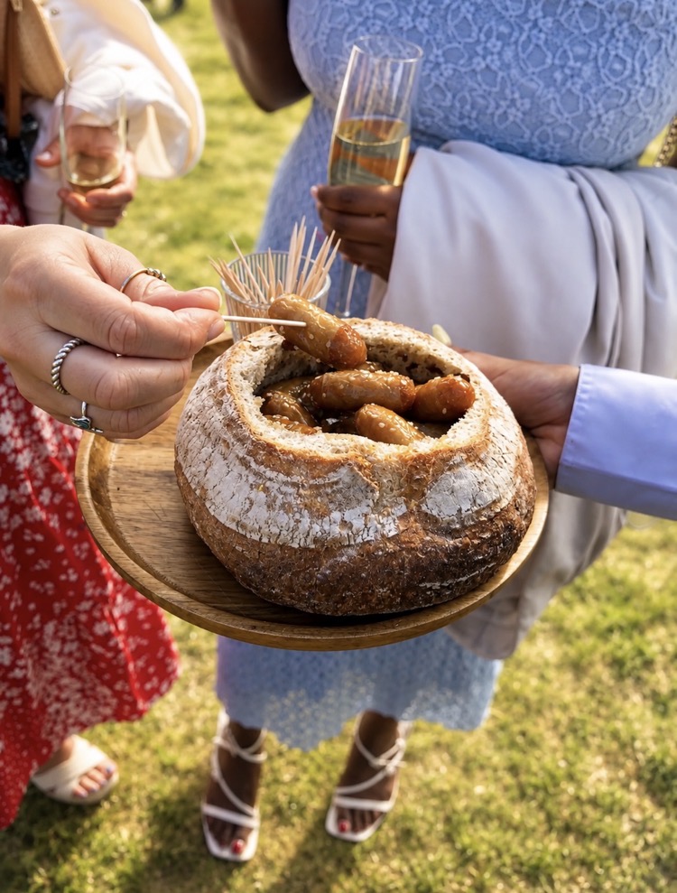 Honey chipolatas served in a hollowed sourdough loaf at an outdoor drinks reception