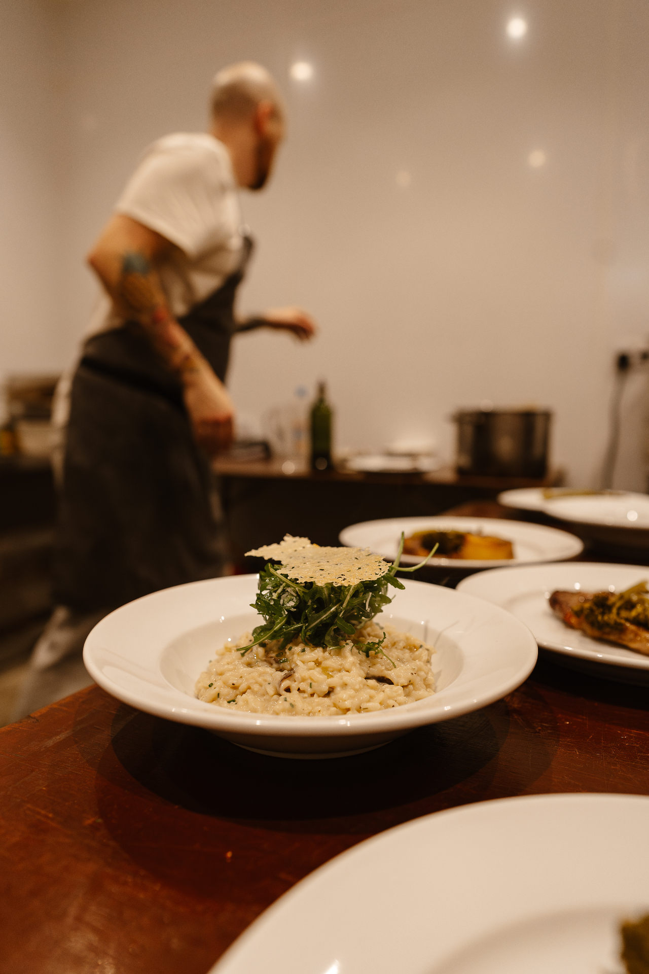 Creamy mushroom risotto topped with rocket and a parmesan crisp, plated at Hill Farm Barns