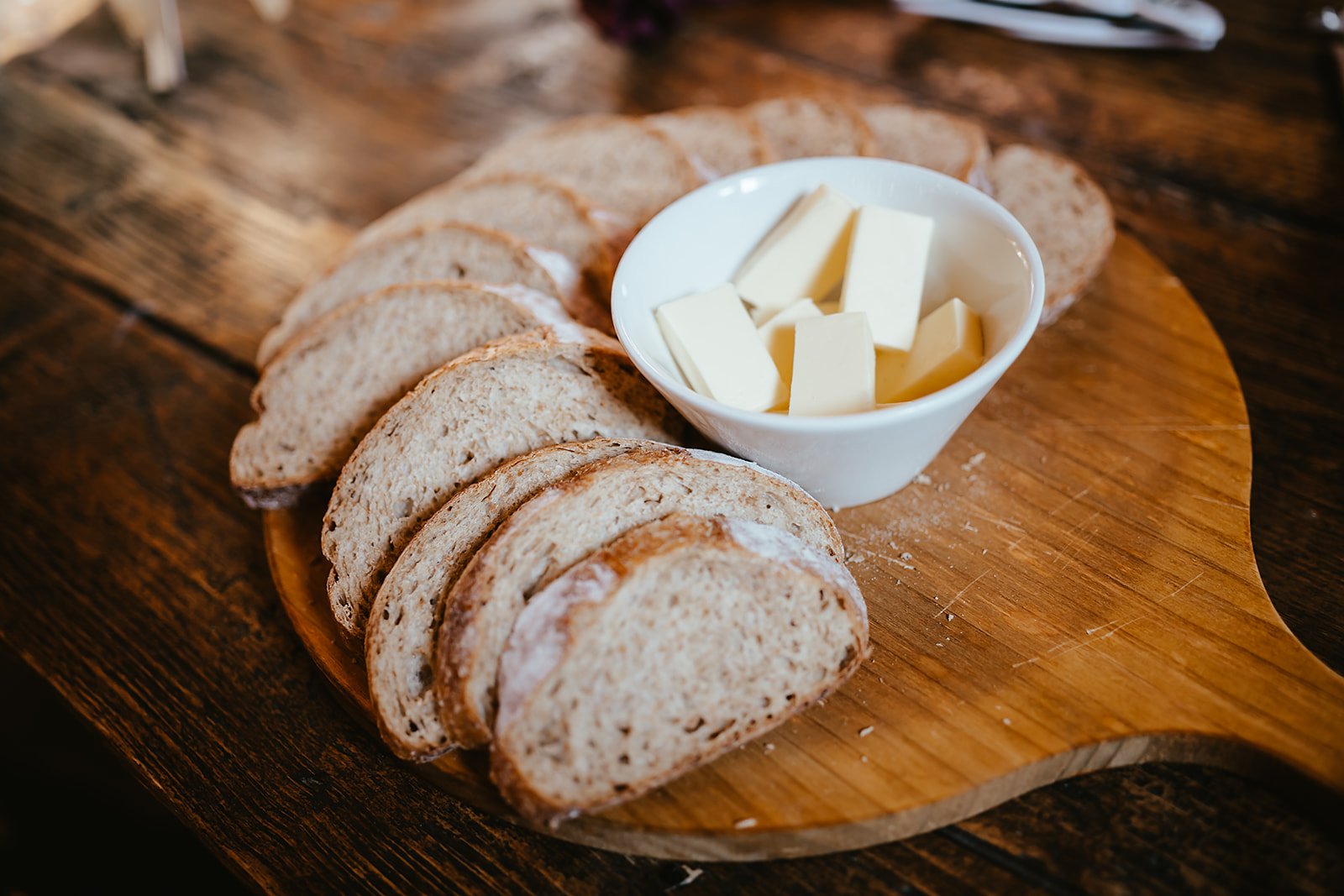 Freshly sliced sourdough with slab butter on a wooden board