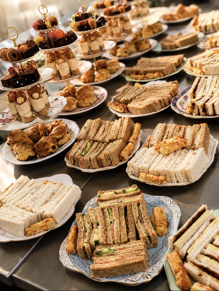 Afternoon tea stands with finger sandwiches, scones, cakes and desserts