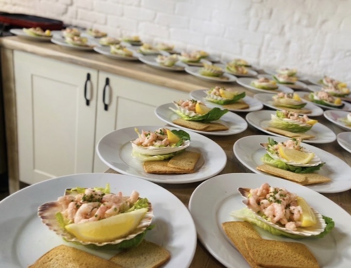 A long line of prawn cocktail starters plated in the kitchen