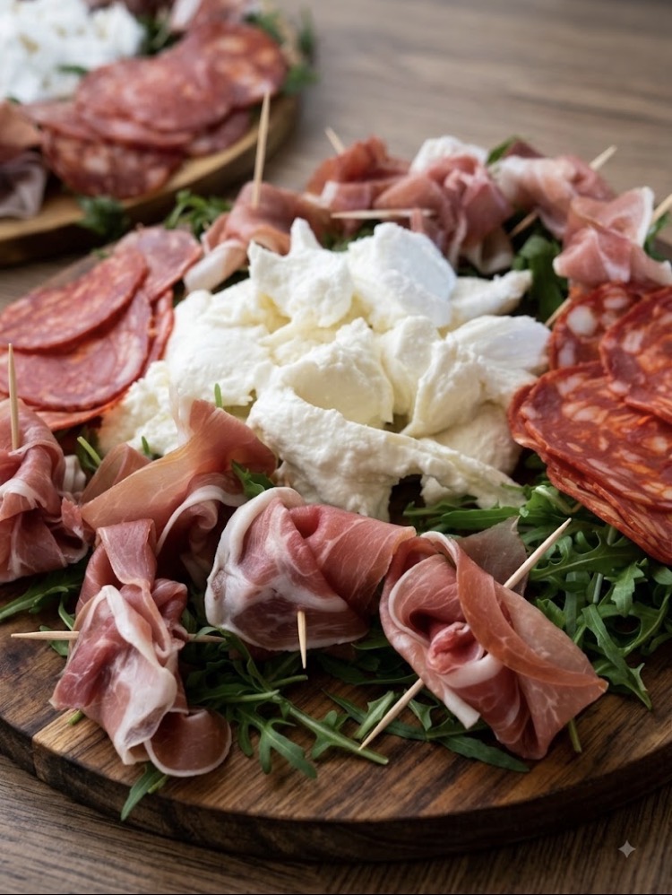 A charcuterie board with cured meats, mozzarella and fresh rocket