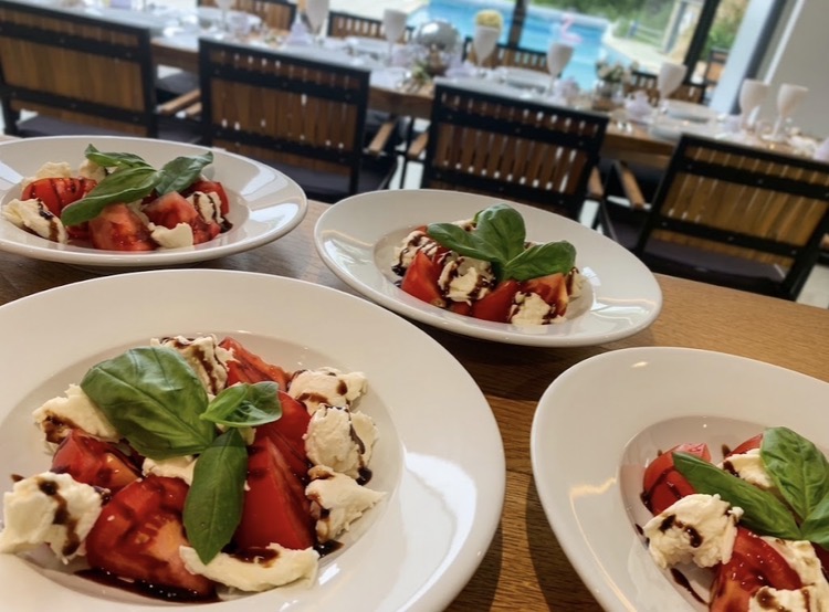 Caprese salad plates with tomato, mozzarella, basil and balsamic glaze