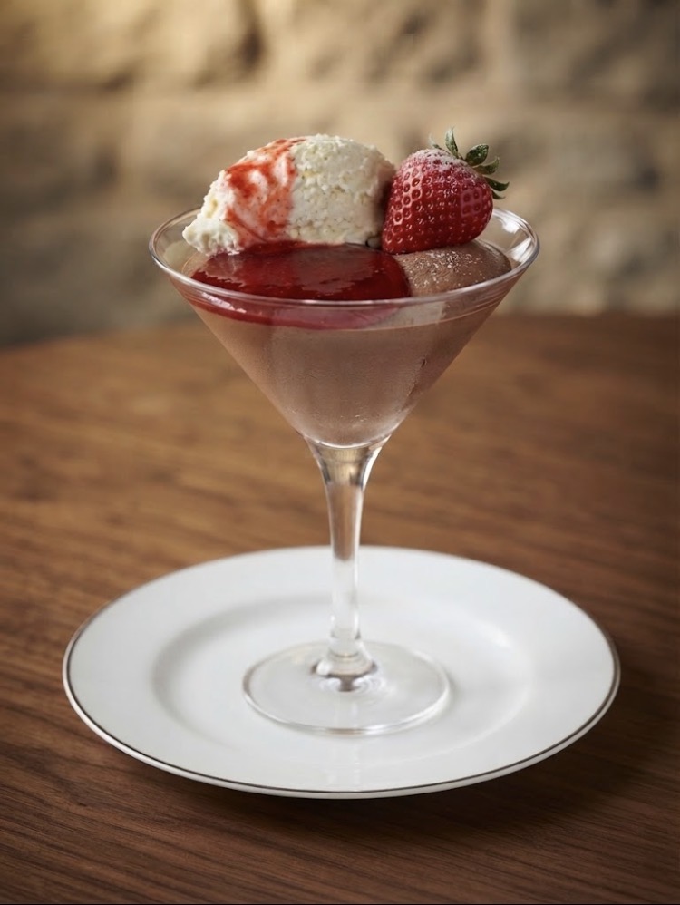 Chocolate mousse in a martini glass topped with ice cream and a fresh strawberry