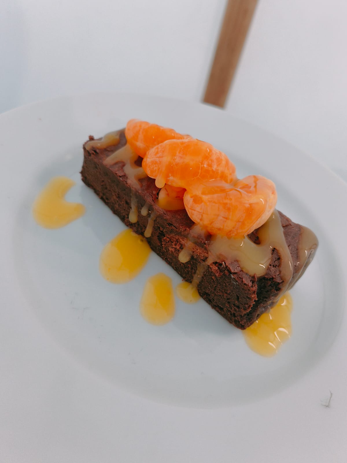 Chocolate brownie with mandarin segments and passion fruit sauce