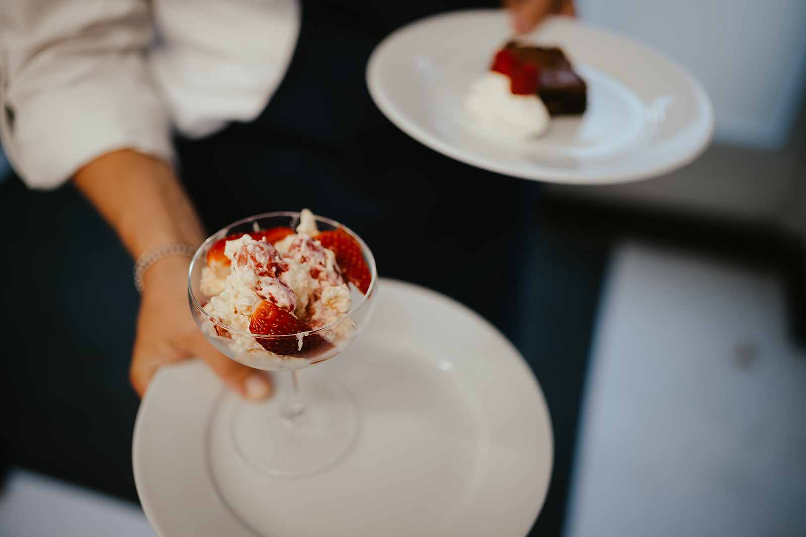 Chef holding a strawberry dessert and a brownie plate