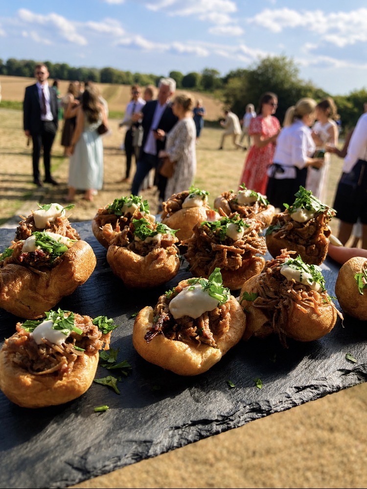 Mini Yorkshire pudding canapés filled with pulled beef and horseradish cream on slate