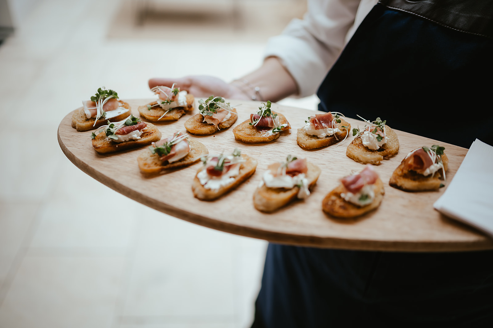 Board of prosciutto and ricotta crostini presented at a Godwick reception