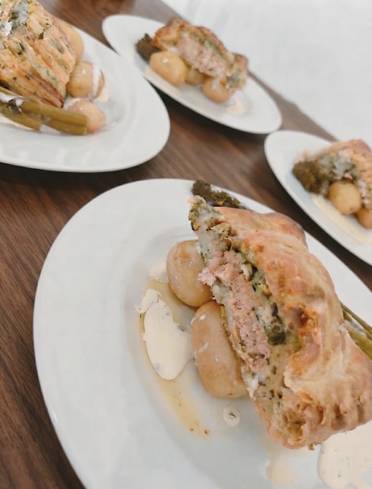 Salmon en croûte with new potatoes, asparagus and herb cream sauce