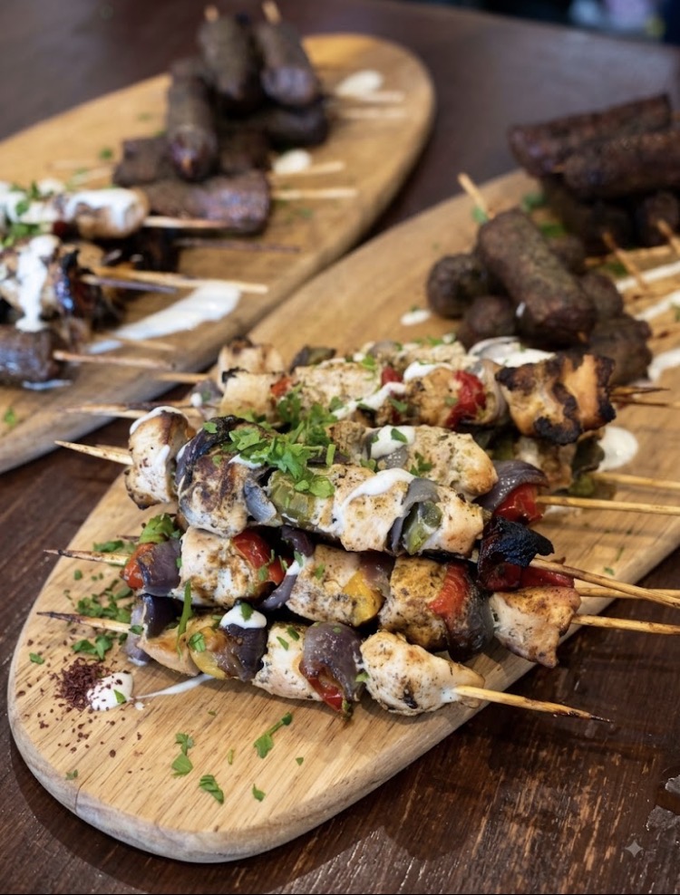 BBQ-style chicken and vegetable skewers with kofta on wooden sharing boards