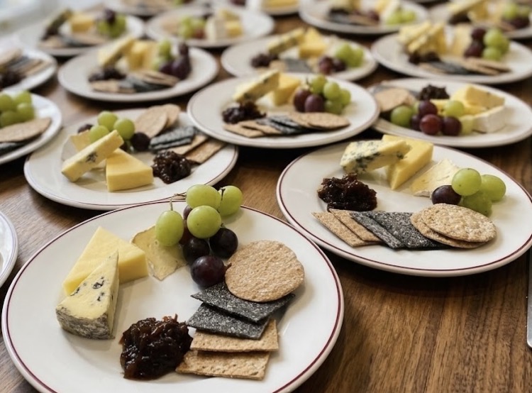 Individual cheese boards with grapes, crackers and chutney on the pass