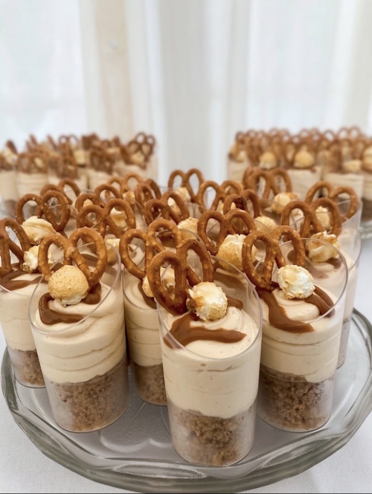 Individual salted caramel cheesecake pots topped with pretzels and caramel popcorn