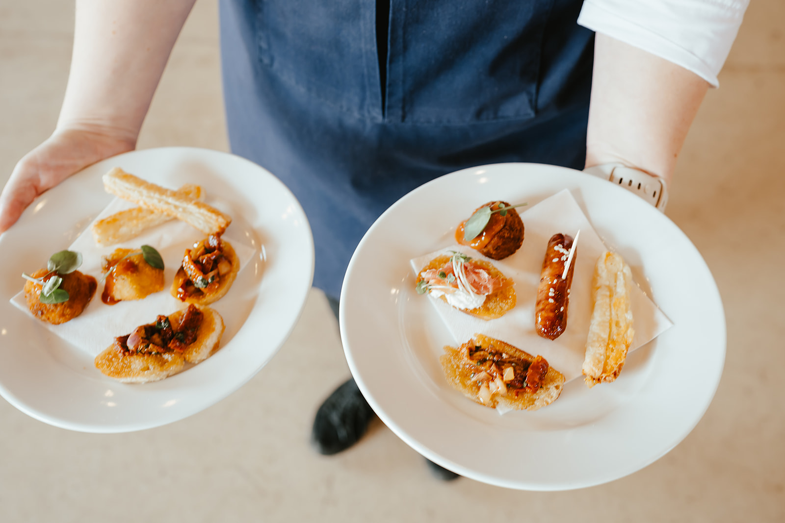 Two plates of assorted canapés carried through the reception